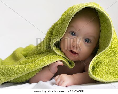 baby in a towel after bathing