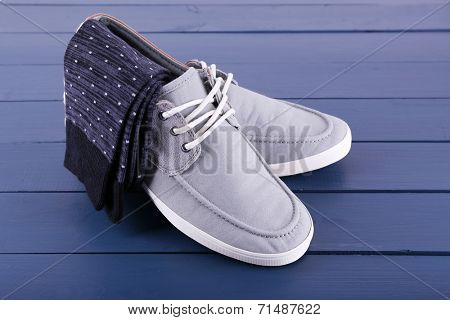 Top-Siders and pair of socks on dark blue wooden background