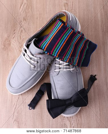 Top-siders, bow-tie and socks on wooden background