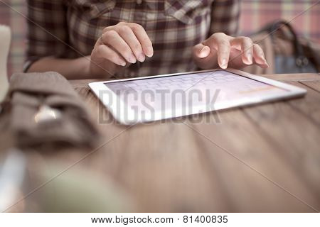 Woman in cafe typing on touch pad