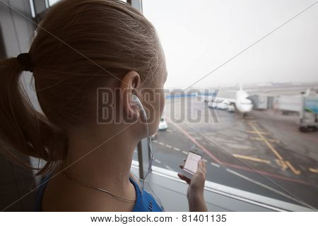 Woman in headphones looking at aiport area