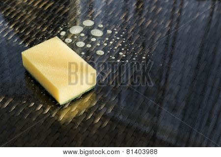 Cleaning glass sufrace sponge over scour liquid composition