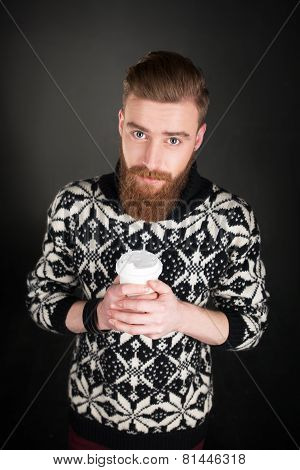 Young man with beard holding a cup of coffee