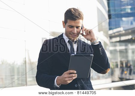 Businessman using a mobile phone and digital tablet