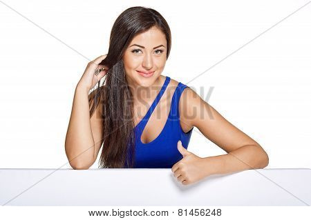 Young pretty woman peeking out from behind the wall