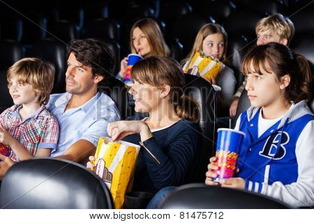 Families having snacks while watching movie in cinema theater