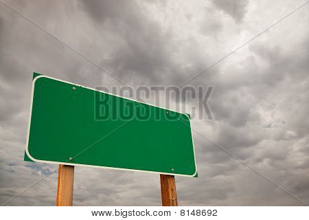 Blank Green Road Sign Over Storm Clouds