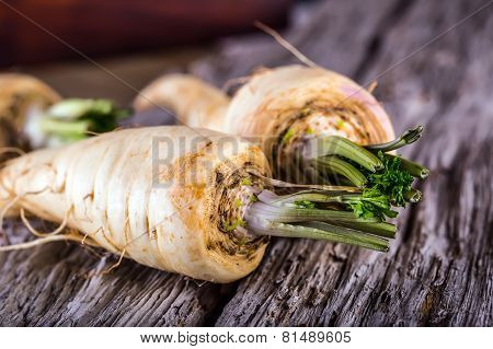 Fresh parsnip on old wooden table.