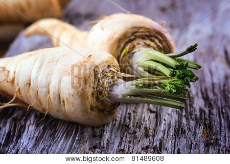 Fresh parsnip on old wooden table.