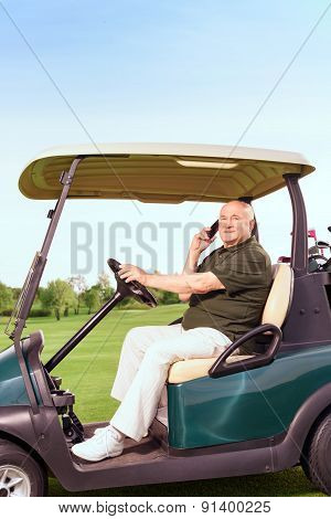 Senior man using mobile phone and driving cart