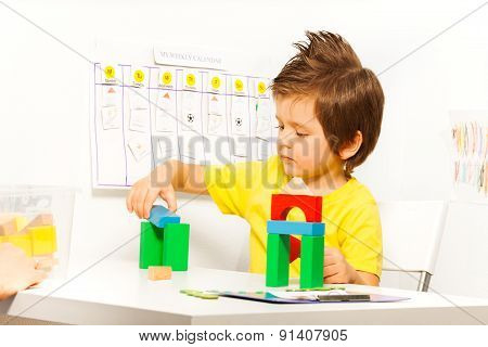 Boy putting colorful cubes in construction game