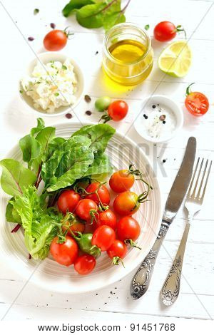 Ingredients For A Fresh Salad With Tomatoes On A White Wooden Surface