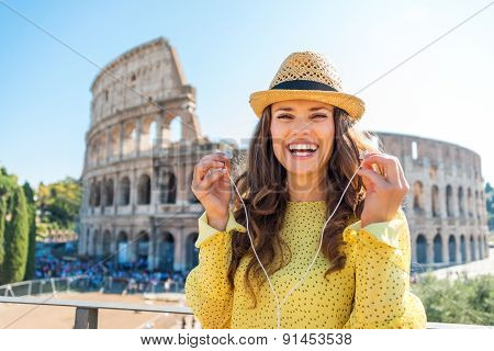 Woman Standing Near Colosseum In Rome Removing Earbuds