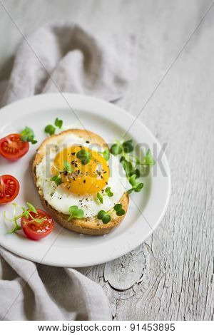 Toast With Egg On A White Plate On A Light Wooden Surface