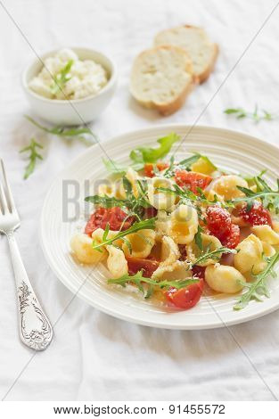 Pasta With Cherry Tomatoes, Arugula And Parmesan On A Light Surface