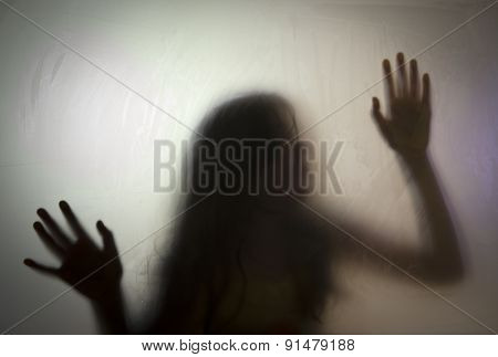 Shadowy figure behind glass 