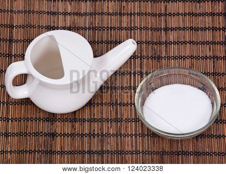 Ceramic neti pot and sea salt in bowl