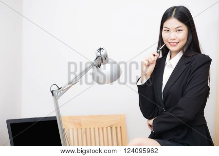 Asian business women sittting in white office with computer