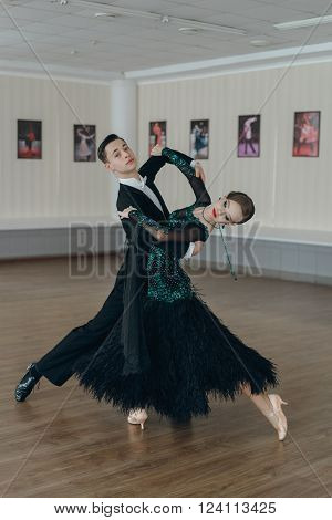Professional dancers dancing in ballroom. Young couple