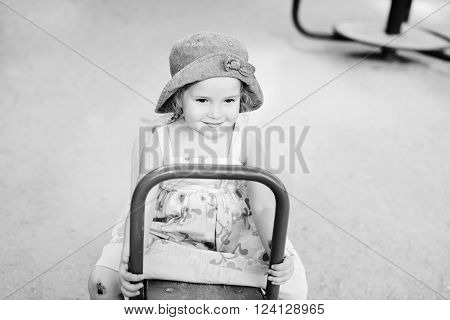 happy toddler girl on the playground in summer