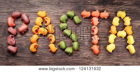 Dry Italian Lumaconi pasta in 5 colours. text pasta