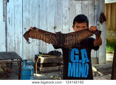 Tentena Indonesia - Dec 12 2015: Man with bat to bat meat for sale to eat in the local market. Central Sulawesi