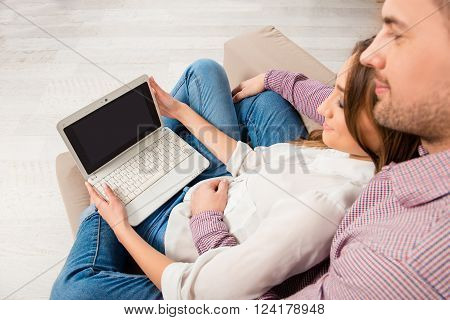 Top View Portrait Of Happy Couple Sitting On Couch With Laptop