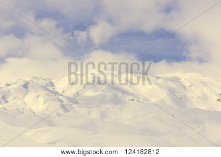 Winter panorama with snow covered slopes and dramatic sky. Komna, Slovenia.