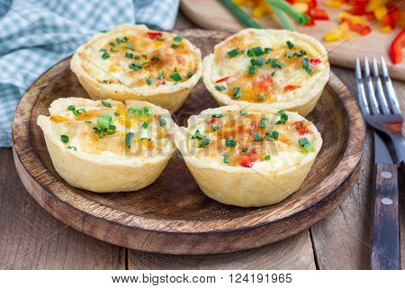 Mini quiche with chicken and bell pepper on a wooden plate
** Note: Shallow depth of field