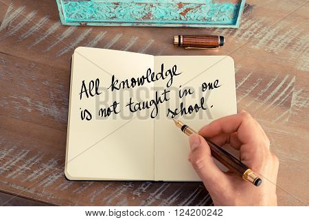 Retro effect and toned image of a woman hand writing on a notebook. Handwritten quote All knowledge is not taught in one school as inspirational concept image