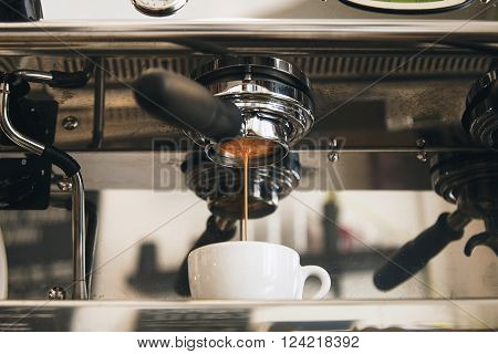Fresh Espresso Coffee Brewing Through The Bottomless Portafilter In White Ceramic Cup In Artisan Caf