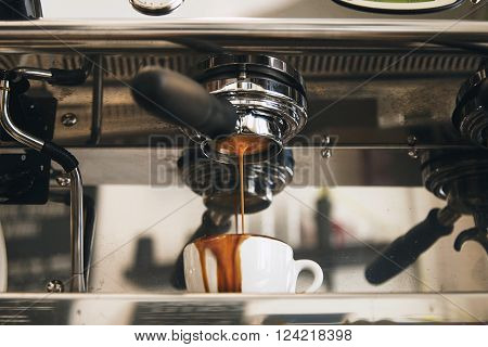 Fresh Espresso Coffee Brewing Through The Bottomless Portafilter In White Ceramic Cup And Leaks Out