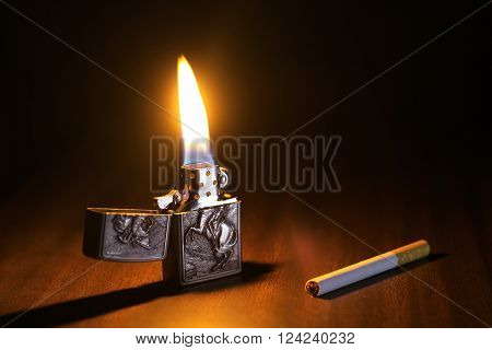 Beautiful Lighter And Cigarette On A Wooden Floor And Lighter's Fire Is Igniting The Dark Enviroment