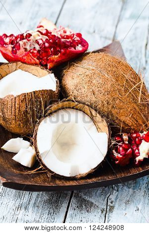 Fresh Coconut And Red Garnet In A Wooden Bowl,blue Background