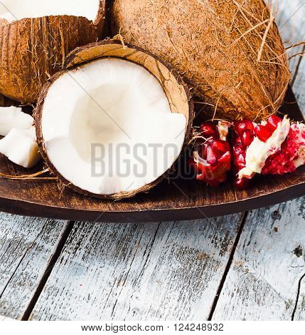 Fresh Coconut And Red Garnet In A Wooden Bowl,blue Background