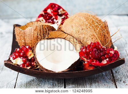 Fresh Coconut And Red Garnet In A Wooden Bowl,blue Background