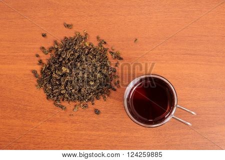 glass mug and poured tea on wooden table