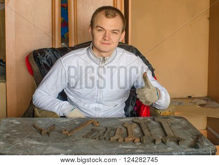 mechanic with thumbs up and wrenches on the table