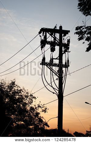 Electricity pole silhouette on sunset city scene