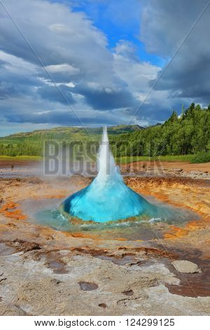 Summer in Iceland. Magnificent geyser Strokkur. Fountain Geyser throws azure water every few minutes