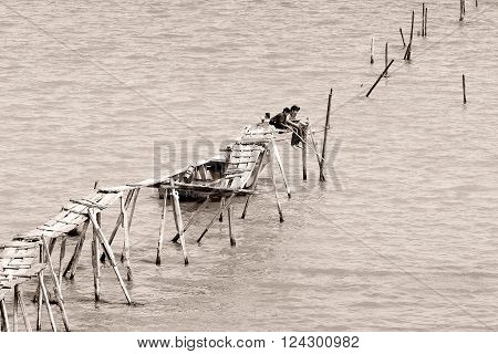 ALAT, AZERBAIJAN - APRIL 14 2014 
Boys fishing in Caspian Sea on broken pier. Alat lies south east of Baku, along Azerbaijan's coast, and fishing is a popular pastime