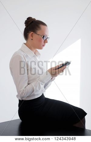 Business woman looking at her smartphone and checking her mails in the city