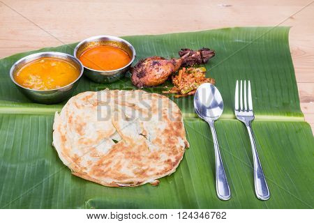 Traditional Roti Prata Served On Banana Leaf With Curry Dhal.