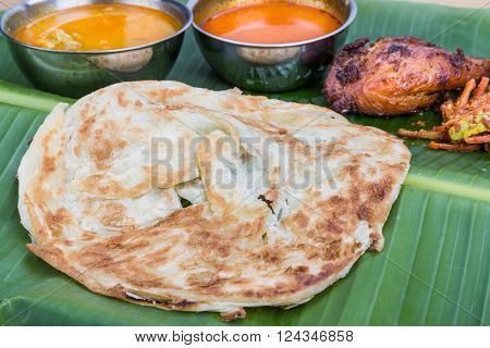 Traditional Roti Prata Served On Banana Leaf With Curry Dhal.