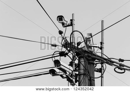 security camera on wooden pole in town