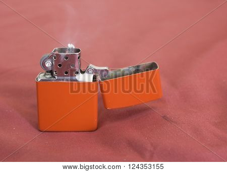 red gasoline lighter with flame on red background