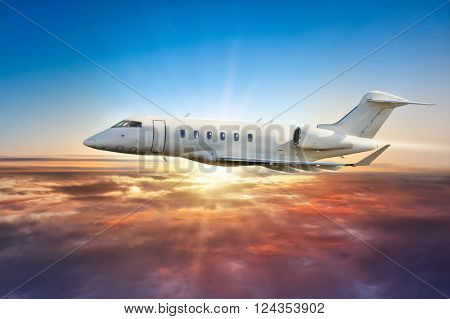 Private jetplane flying above clouds in sunset