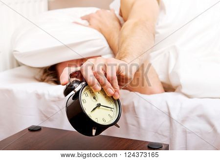 Man trying to sleep, when alarm clock ringing