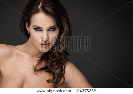Sexy brunette woman posing on dark background
