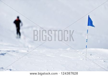 Blue flag blown by the wind on a mountain in winter and skier in background
** Note: Visible grain at 100%, best at smaller sizes